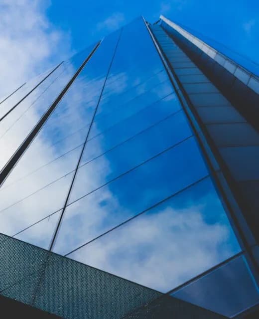 Glass office tower reflecting the sky